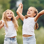 Dołącz do Uniwersytetu Dzieci i Rodziców. Rekrutacja na rok akademicki 2025/2026 grupa dzieci trzymających się za ręce uchwycona w podskoku